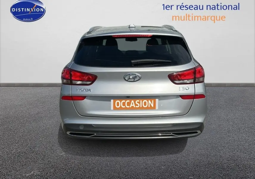Vue arrière d'une Hyundai i30 SW gris clair avec vitres surteintées et plaque "OCCASION" visible.