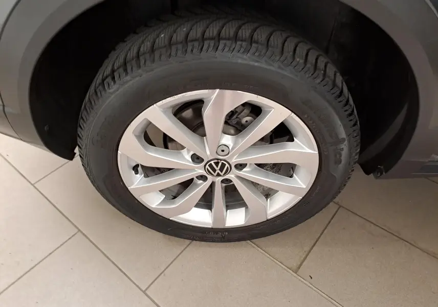 Gros plan sur la jante alliage 17'' Johannesburg argentée du Volkswagen T-Roc gris Indium, roue avant droite visible.