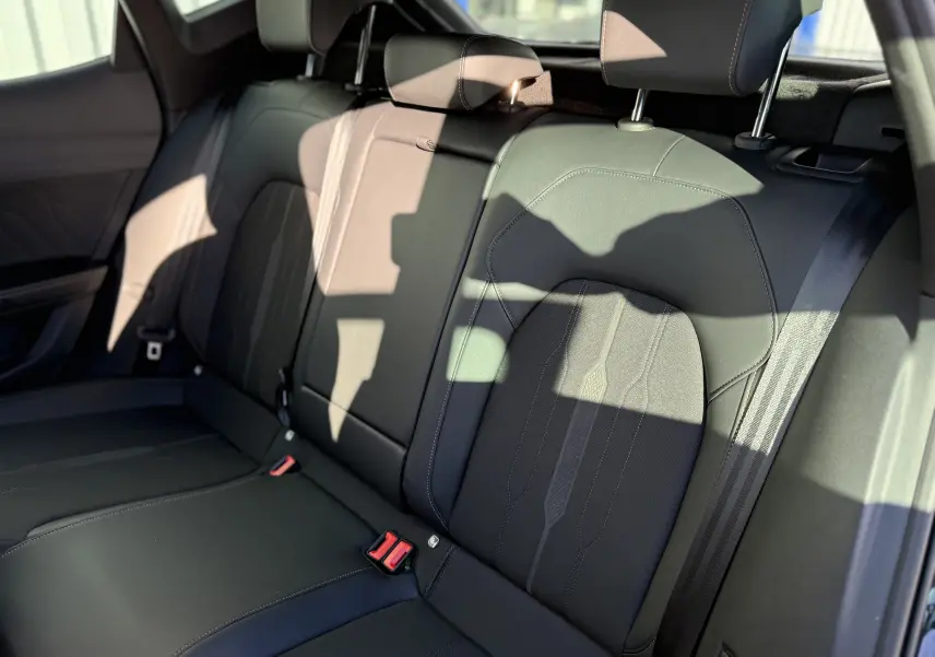 Vue intérieure des sièges arrière noirs en tissu et cuir du CUPRA Formentor 2023, avec ceintures de sécurité visibles.