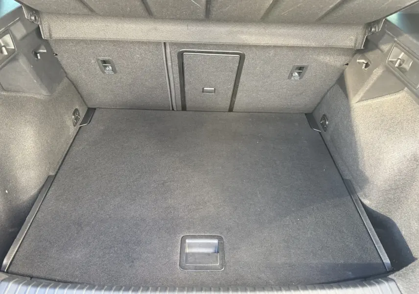 Coffre spacieux et propre du CUPRA Formentor 2023 en noir minuit, vue intérieure depuis l'arrière avec revêtement tissu gris foncé.