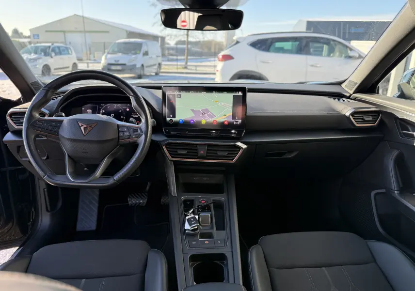 Intérieur noir du CUPRA Formentor 2023, vue de face sur le tableau de bord avec écran tactile central et volant multifonction.