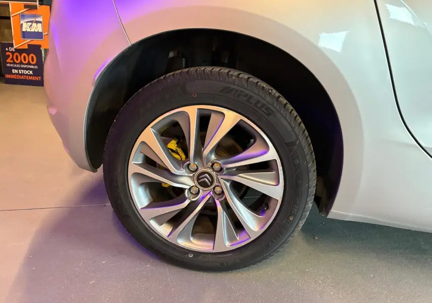 Gros plan sur la roue arrière droite gris clair d'une DS4 1.6 HDI 115 avec jante alliage et frein jaune visible.