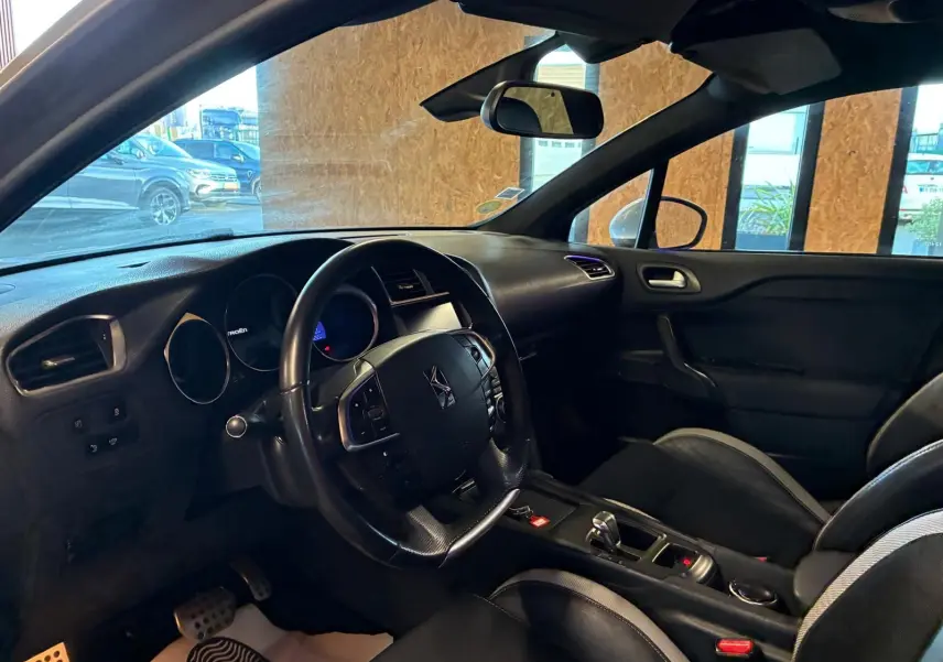 Intérieur côté conducteur de la DS4 gris, vue sur le volant multifonction et la console centrale avec boîte automatique.