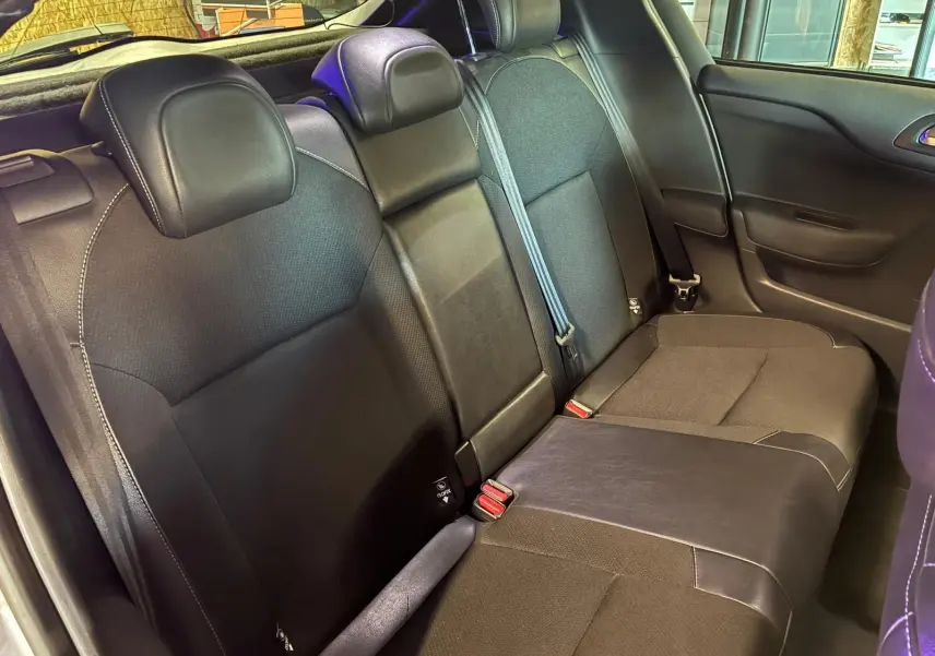 Vue intérieure côté droit des sièges arrière en tissu gris et noir du DS4 gris 2014 avec ceintures de sécurité visibles.