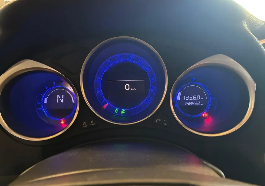 Vue rapprochée du tableau de bord du DS4 gris 2014, affichant les compteurs numériques bleus et les voyants allumés.