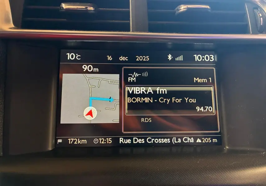 Écran central du tableau de bord du DS4 gris, affichant la navigation GPS et la radio FM en intérieur.