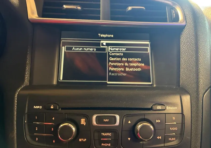 Vue rapprochée du tableau de bord gris noir du DS4 2014, écran central affichant le menu téléphone avec options Bluetooth.