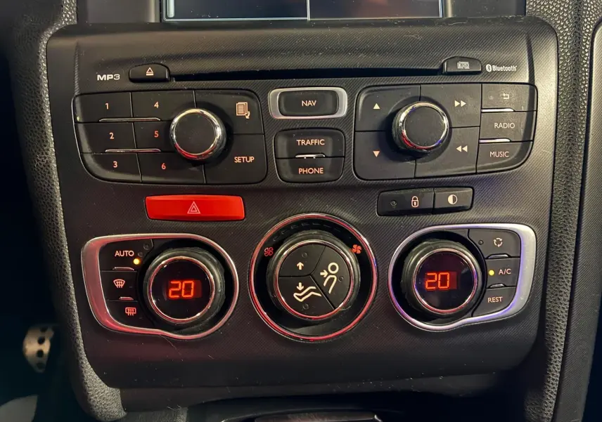 Gros plan sur la console centrale du DS4 gris 2014, montrant les commandes de climatisation et radio avec affichage digital rouge.