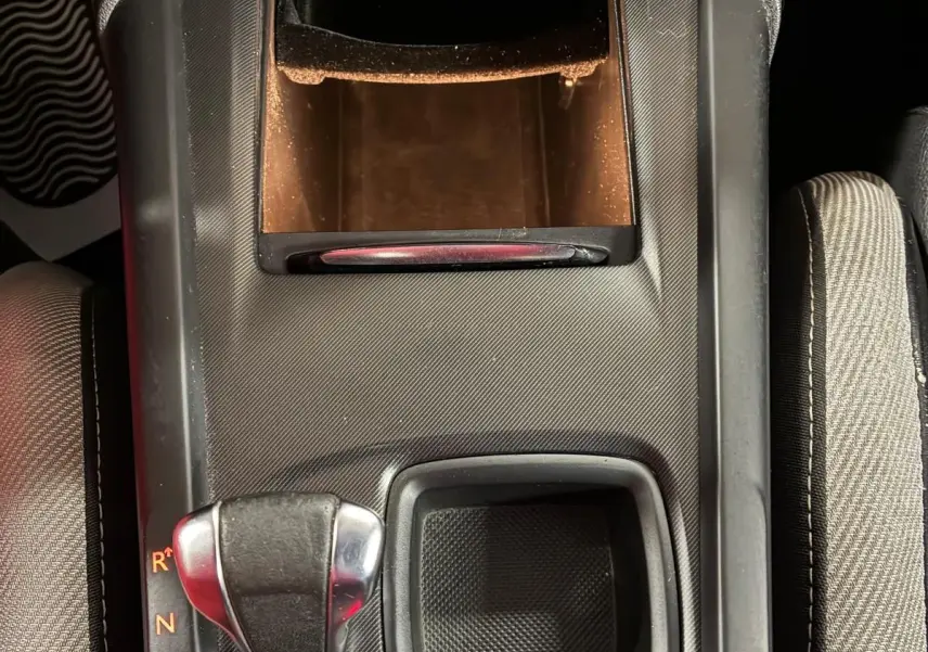 Vue plongeante sur la console centrale noire de la DS4 2014, avec levier de boîte automatique et rangement ouvert.