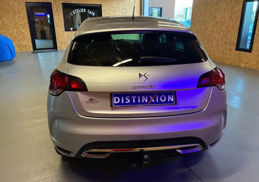Vue arrière d'une DS4 gris métallisé 2014 avec feux rouges et attelage visible en intérieur showroom.