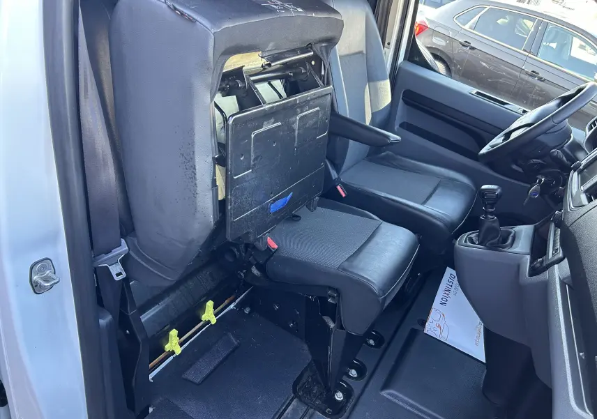 Vue intérieure côté conducteur du Citroën Jumpy blanc 2017, siège passager relevé avec tablette intégrée.