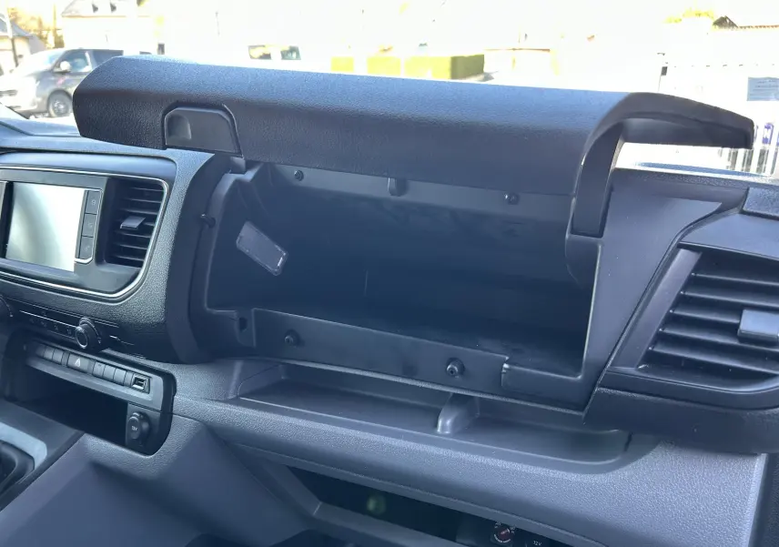 Intérieur du Citroën Jumpy 2017, vue sur la boîte à gants ouverte côté passager avec tableau de bord noir.
