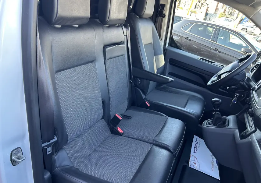 Vue intérieure côté conducteur du Citroën Jumpy blanc de 2017, montrant les sièges avant en tissu et cuir avec levier de vitesse manuel.