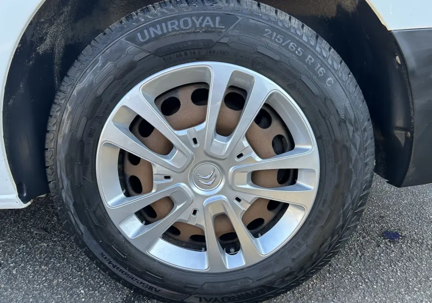Gros plan sur la roue avant droite d'un Citroën Jumpy blanc de 2017 avec jante argentée et pneu Uniroyal.