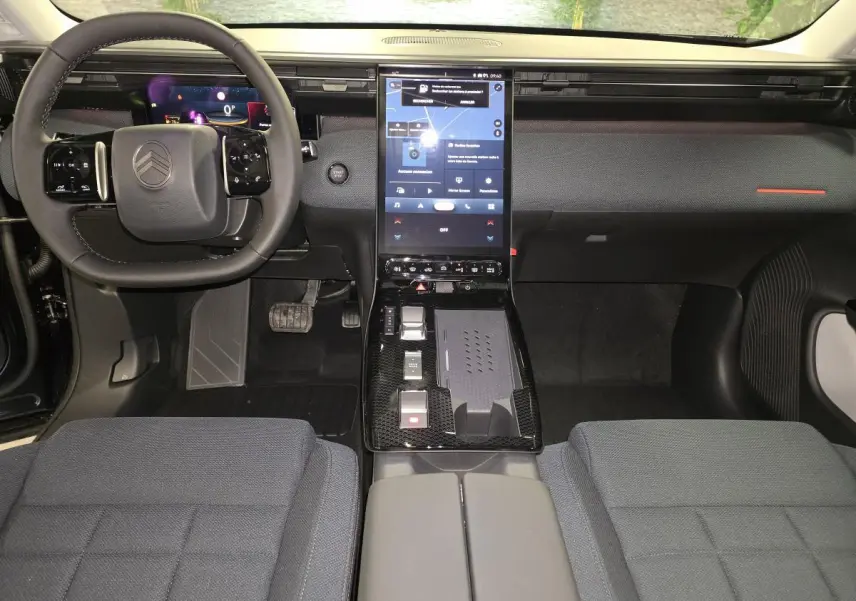 Vue intérieure avant du Citroën C5 Aircross 2026, tableau de bord noir avec grand écran tactile vertical et volant multifonctions.