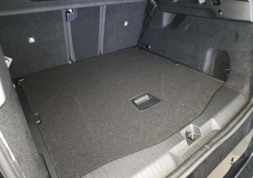 Vue intérieure du coffre spacieux et noir du Citroën C5 Aircross 2026, avec plancher plat et poignée centrale.