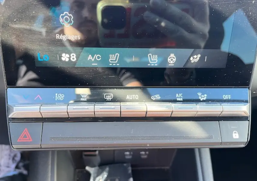 Gros plan sur la console centrale tactile du Renault Symbioz 2025, affichant les commandes de climatisation et sécurité.