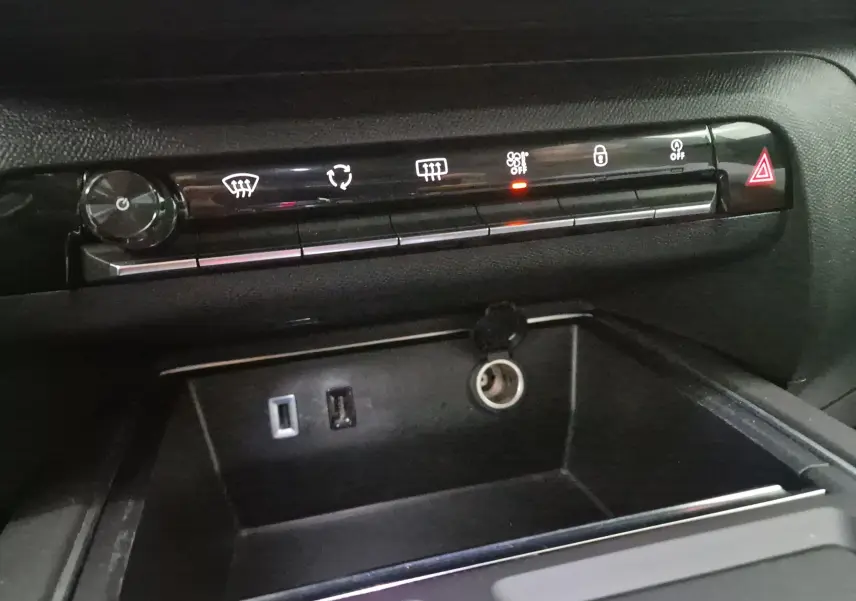 Vue rapprochée de la console centrale noire du Citroën C5 Aircross 2024, montrant les commandes climatisation et ports USB.