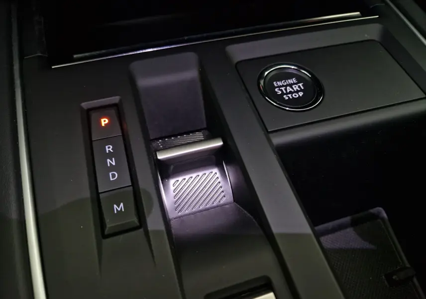 Gros plan sur la console centrale noire du Citroën C5 Aircross 2024 avec levier de vitesses automatique et bouton start/stop.