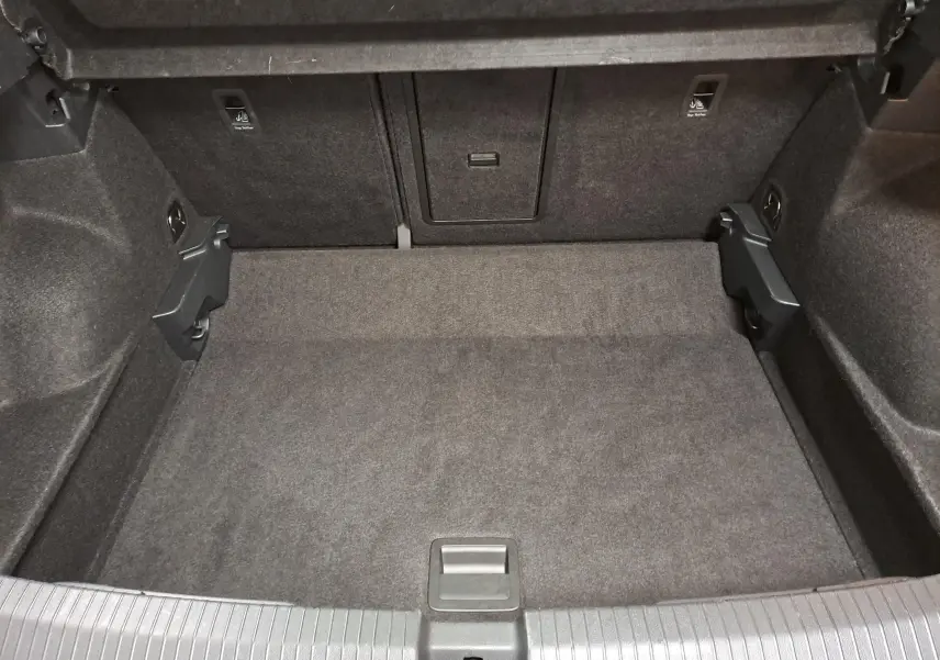 Coffre vide du Volkswagen T-Roc 2024, vue intérieure arrière, revêtement tissu gris foncé sans chargement visible.
