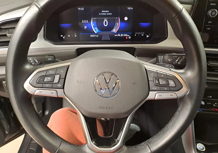 Vue rapprochée du volant multifonction d’un Volkswagen T-Roc 2024 avec tableau de bord numérique allumé.