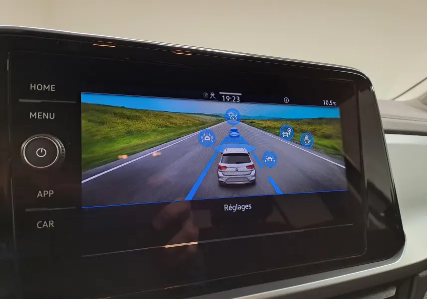 Écran tactile du tableau de bord montrant les aides à la conduite du Volkswagen T-Roc 2024 en vue arrière virtuelle.
