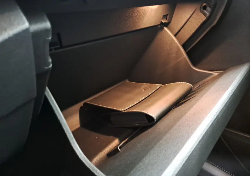 Gant de poche en cuir noir dans la boîte à gants du Volkswagen T-Roc 2024, intérieur sombre et sobre.