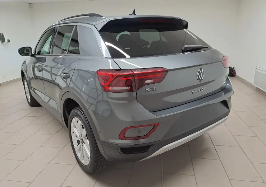 Vue 3/4 arrière droite d'un Volkswagen T-Roc 2024 gris Indium avec jantes alliage 17'' Johannesburg et caméra de recul.