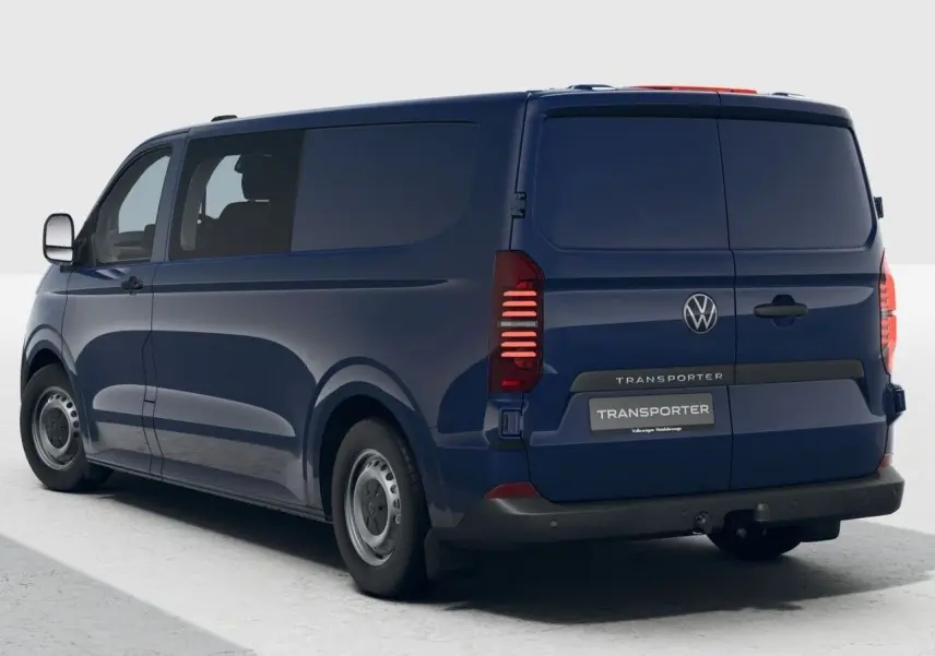 Vue 3/4 arrière droite du Volkswagen Transporter ProCab bleu 2025 avec vitres teintées et attelage visible.