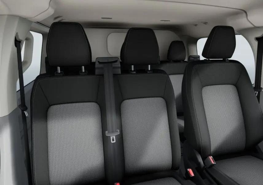 Vue intérieure sur les sièges avant et arrière en tissu gris et noir du Volkswagen Transporter ProCab T7 2025.