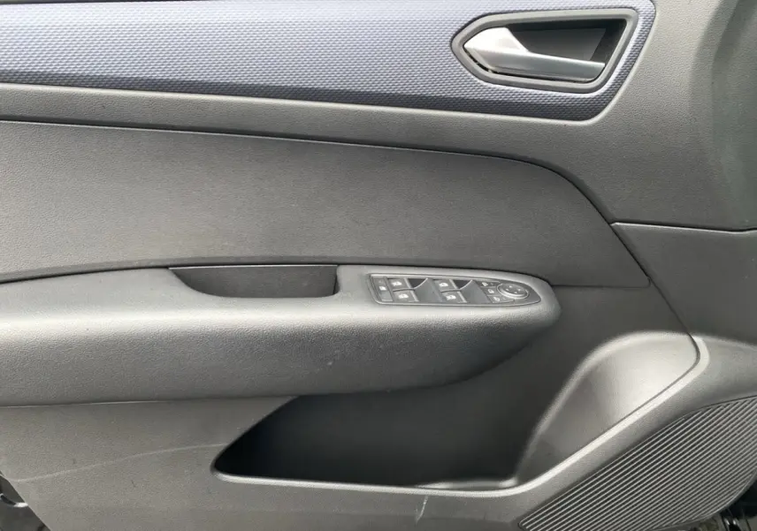 Détail de la porte intérieure côté conducteur de la Renault Arkana 2024 noire, avec commandes de vitres et poignée argentée.