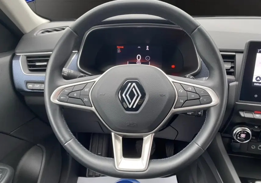 Vue rapprochée du volant cuir et alu du Renault Arkana noir 2024 avec tableau de bord numérique et écran tactile central.
