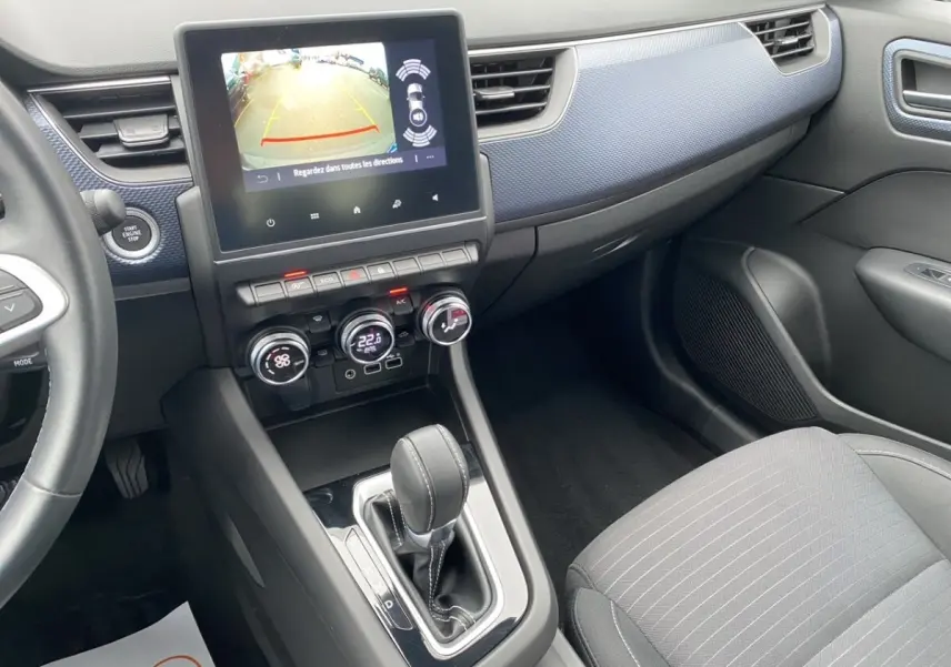 Vue intérieure côté passager du tableau de bord et console centrale du Renault Arkana noir avec écran tactile et levier de boîte auto.