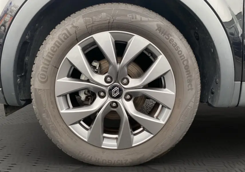Gros plan sur la roue avant gauche d’un Renault Arkana noir, mettant en valeur la jante alliage argentée et le pneu Continental.