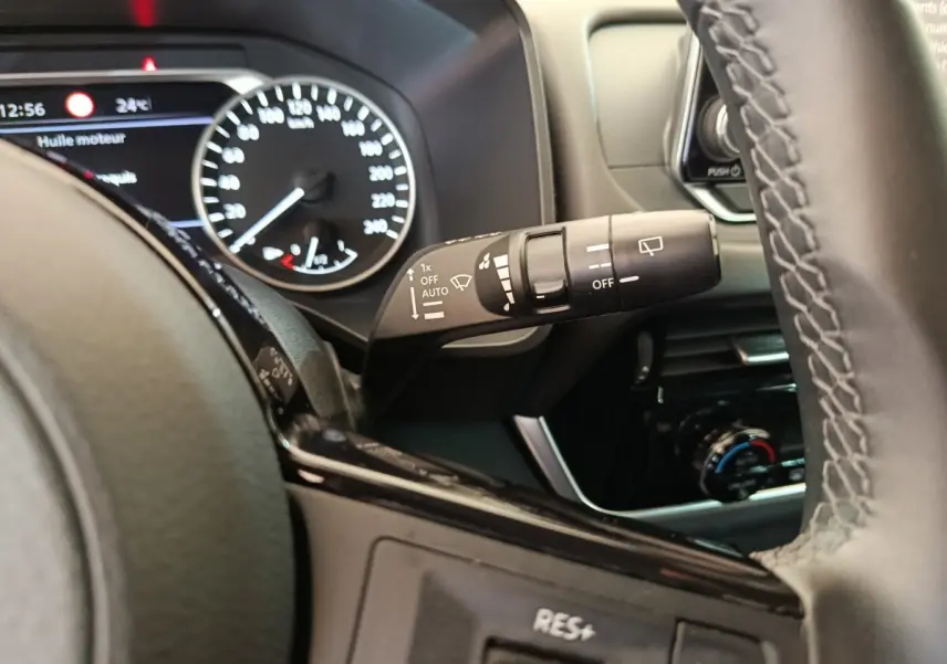Gros plan intérieur sur le volant noir et la commande d’essuie-glace du Nissan Qashqai e-Power 2024.