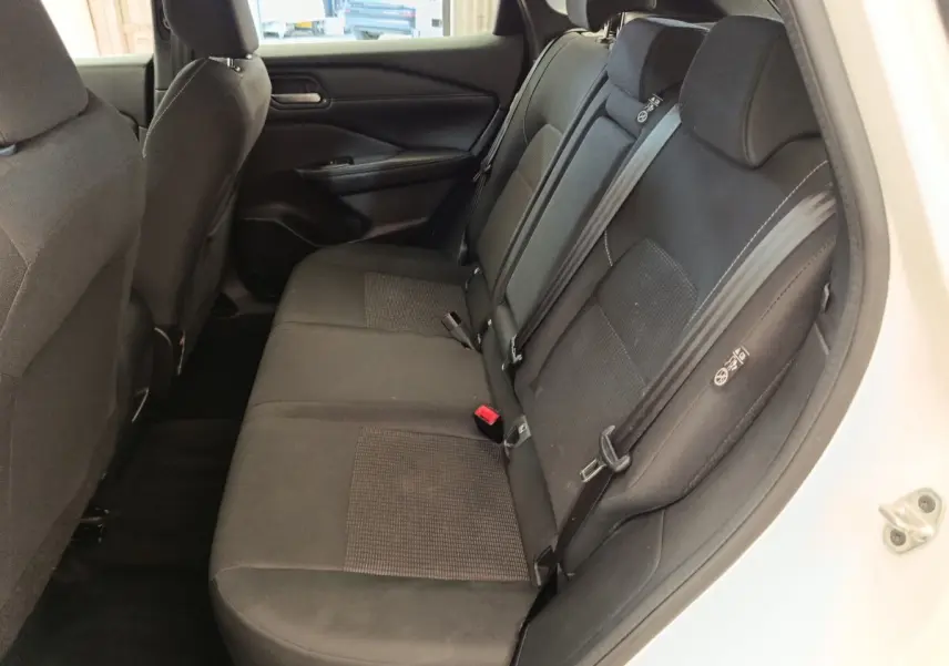 Vue intérieure côté droit des sièges arrière noirs du Nissan Qashqai e-Power 2024 avec ceintures de sécurité visibles.
