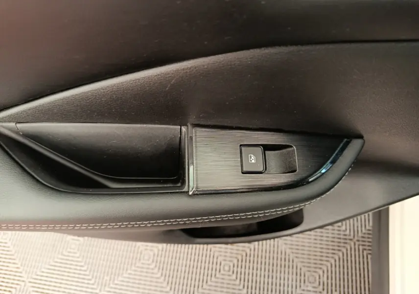 Gros plan sur la commande de verrouillage de porte côté conducteur du Nissan Qashqai e-Power blanc 2024.