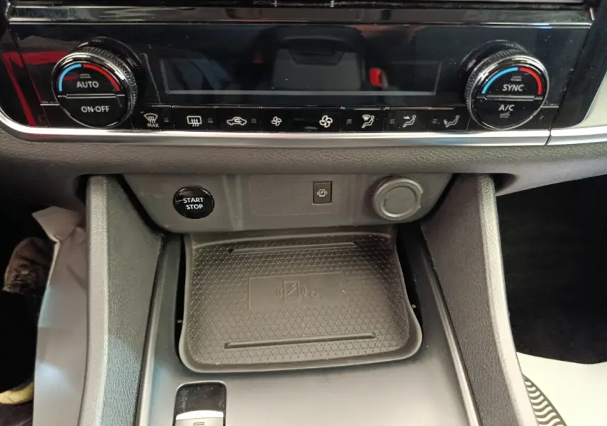 Gros plan intérieur sur la console centrale du Nissan Qashqai e-Power 2024, avec commandes climatisation et bouton start/stop.