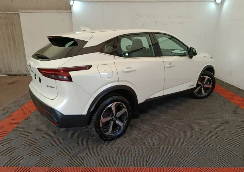 Vue 3/4 arrière droite du Nissan Qashqai e-Power blanc avec jantes alliage et toit noir dans un garage.