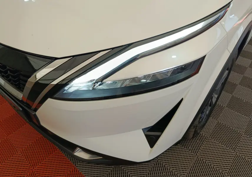 Gros plan sur l'avant droit blanc du Nissan Qashqai e-Power 190 avec phares LED et calandre chromée.