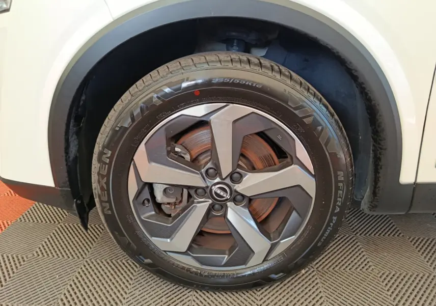 Gros plan sur la roue avant droite du Nissan Qashqai blanc 2024 avec jante alliage et pneu Nexen.