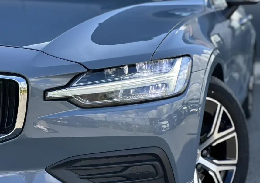 Gros plan sur l'avant droit d'une Volvo S60 gris Thunder, mettant en valeur son phare LED et jante alliage 17 pouces.