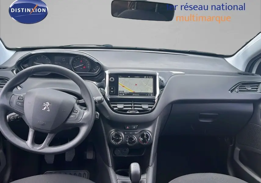 Intérieur de la Peugeot 208 blanc banquise, vue frontale du tableau de bord avec écran tactile et volant multifonction.