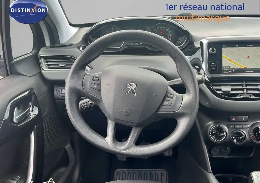 Vue intérieure centrée sur le volant Peugeot 208 2020, tableau de bord et écran tactile avec navigation visible.