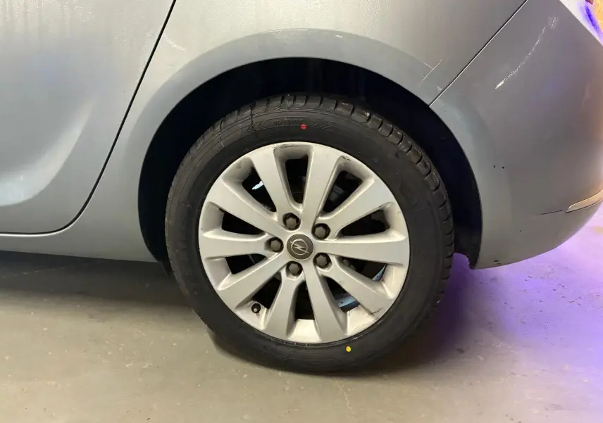 Gros plan sur la roue arrière droite grise d'une Opel Astra 1.6 CDTI 110 diesel de 2015 avec jante alliage.