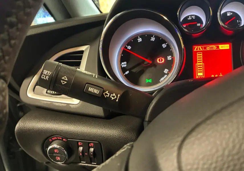 Vue rapprochée du tableau de bord gris d'une Opel Astra 2015, avec compte-tours et commandes au volant visibles.