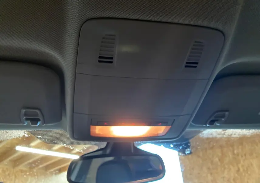 Vue intérieure du plafonnier allumé et du rétroviseur central d'une Opel Astra gris 2015.