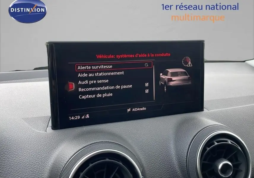 Écran central affichant les aides à la conduite du tableau de bord d'un Audi Q2 noir mito metal de 2023.