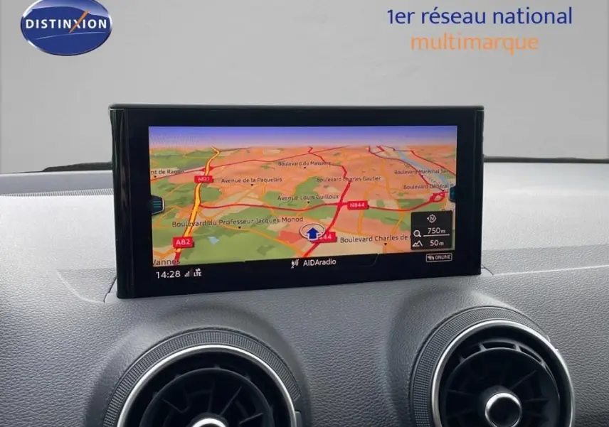 Écran central du tableau de bord de l'Audi Q2 2023 noir, affichant la navigation GPS avec carte routière colorée.