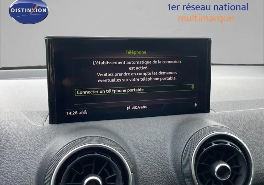 Écran central affichant la connexion Bluetooth dans l'habitacle d'un Audi Q2 noir mito metal, vue intérieure avant.